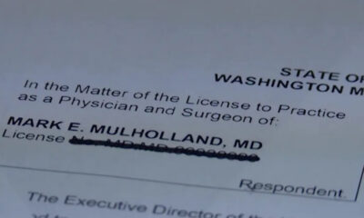 Close-up of a Washington medical license form showing the name Mark E. Mulholland, MD with the license line obscured/blurred.