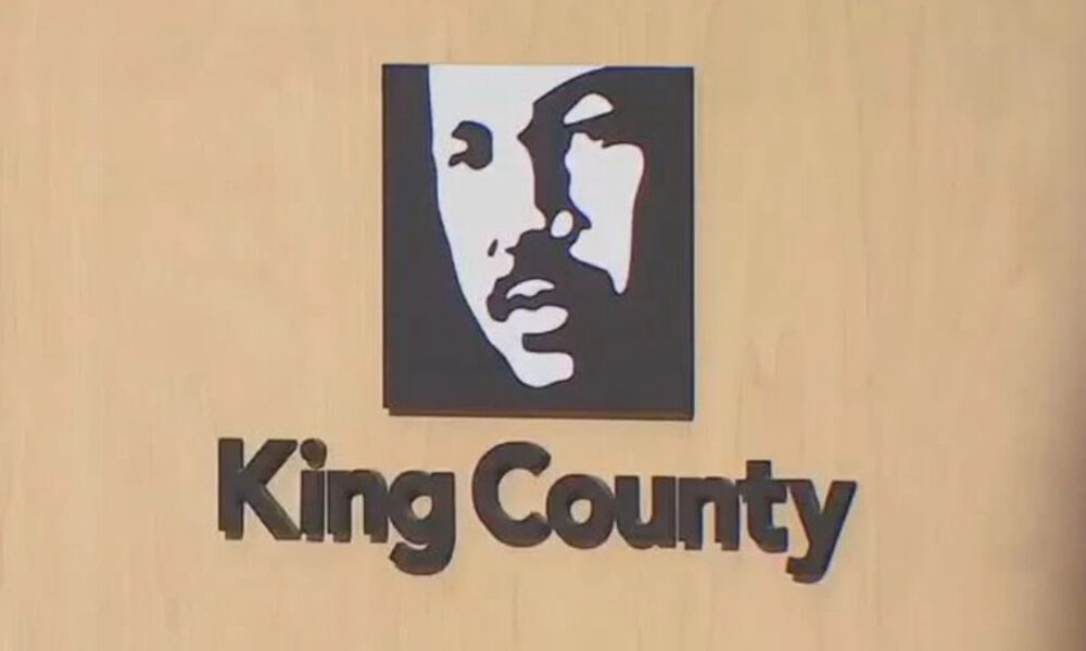 Logo: stylized black-and-white face in a square above the text 'King County' on a wood background.
