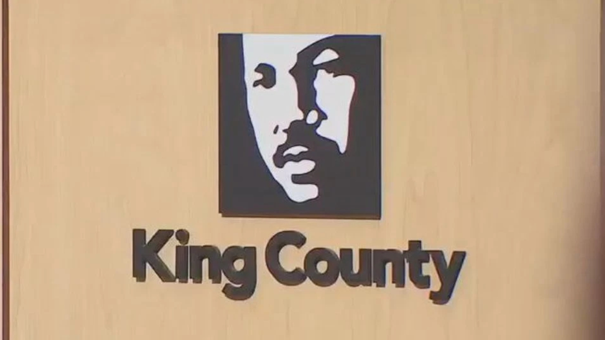 Logo: stylized black-and-white face in a square above the text 'King County' on a wood background.