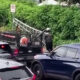 Emergency responders stand on the back of a black pickup with a long ladder extended, loading equipment on a crowded street; FOX13 logo in the lower-left corner.