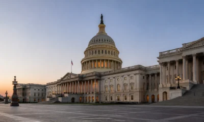 Wide-angle view of the U.S. Capitol in Washington, D.C. with its dome lit at sunset and grand neoclassical wings on either side, plus steps in the foreground.
