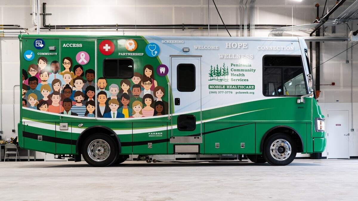 Green mobile health care bus with cartoon crowd artwork and 'Peninsula Community Health Services' branding on the side, serving as a mobile clinic.
