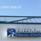 Exterior of a driving school building with a blue logo and sign reading 'FREEDOM Driving School'