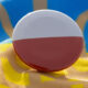 Round pin badge showing the Polish flag (white over red) on a blue and yellow fabric background.
