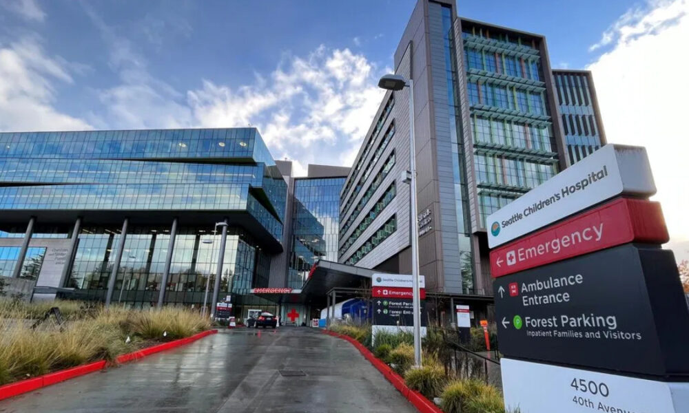 Modern hospital campus with glass-fronted buildings and an Emergency entrance sign
