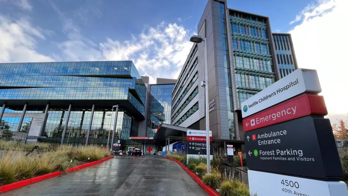 Modern hospital campus with glass-fronted buildings and an Emergency entrance sign