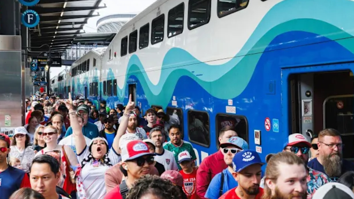Crowded train platform with a blue and teal wave-patterned double-decker train and passengers boarding. Crowded train platform with a blue and teal wave-patterned double-decker train and passengers boarding.