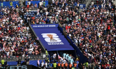 Large crowd gathered in a stadium for FIFA World Cup 2026, with a blue tunnel entrance and logo banner visible in the center