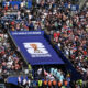 Large crowd gathered in a stadium for FIFA World Cup 2026, with a blue tunnel entrance and logo banner visible in the center