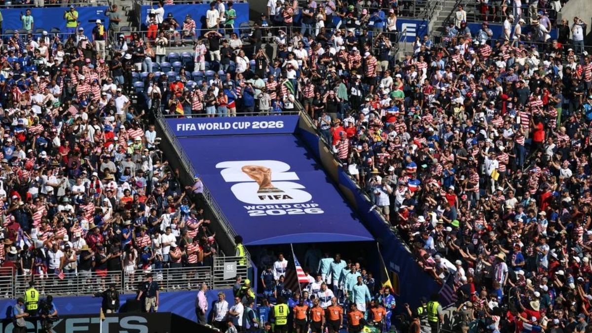 Large crowd gathered in a stadium for FIFA World Cup 2026, with a blue tunnel entrance and logo banner visible in the center