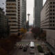 Downtown street with high-rise buildings on both sides and the Space Needle visible in the distance.
