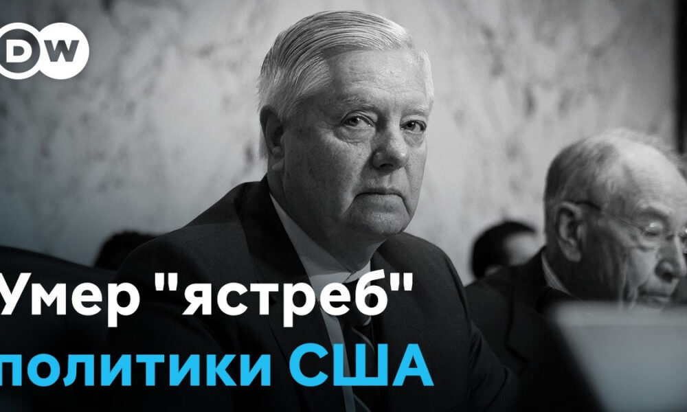 Grayscale photo of a stern older man in a suit at a hearing; overlaid Russian headline reads 'Умер "ястреб" политики США' with the words 'политики США' in blue (DW logo top-left).
