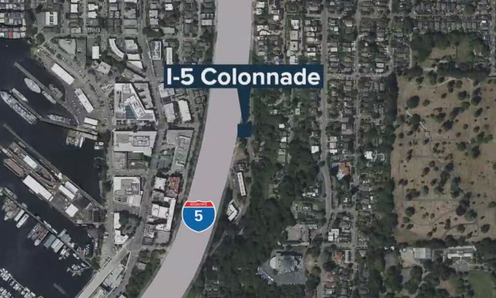 Aerial map showing I-5 Colonnade label along a highway beside a marina and buildings in a coastal city.