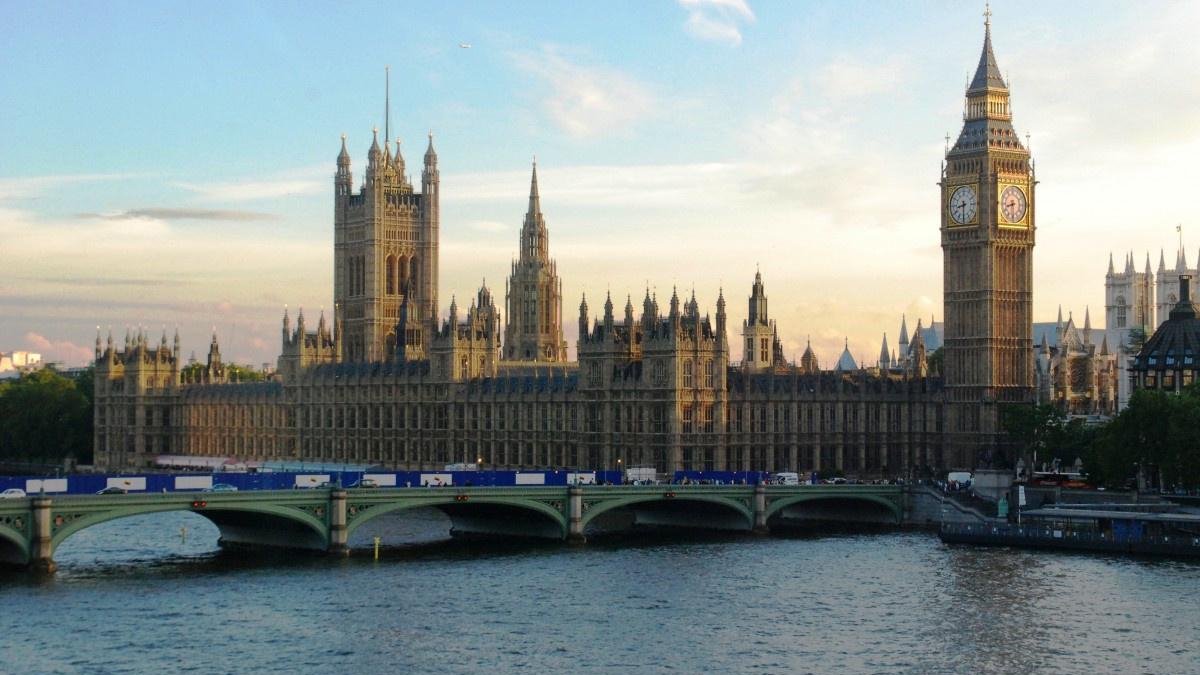 Sunlit view of the Palace of Westminster with Big Ben along the River Thames, seen from Westminster Bridge.