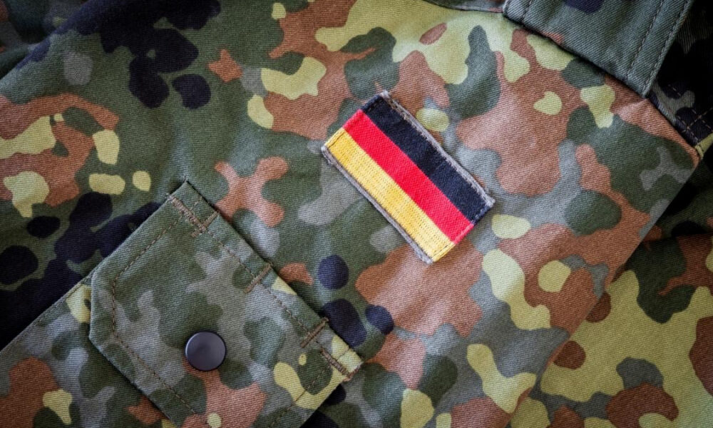 Camouflage military jacket sleeve with a rectangular German flag patch