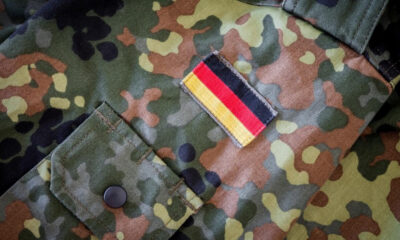 Camouflage military jacket sleeve with a rectangular German flag patch
