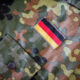 Camouflage military jacket sleeve with a rectangular German flag patch