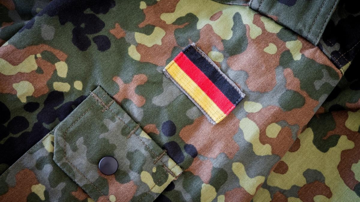 Camouflage military jacket sleeve with a rectangular German flag patch