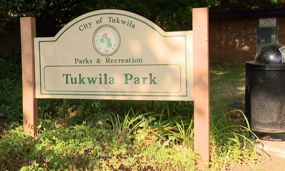 Park entrance sign reading 'Tukwila Park' under Parks & Recreation, City of Tukwila, with green border and a trash can nearby.