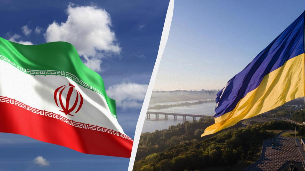 Iranian flag waving on the left with green‑white‑red stripes and red emblem, against a blue sky; Ukrainian flag waving on the right over a river and hillside landscape with a bridge, split by a diagonal divider.