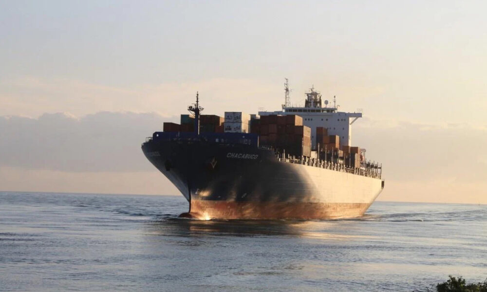 Container ship CHACABUCO at sea with stacked cargo containers under sunset light