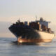 Container ship CHACABUCO at sea with stacked cargo containers under sunset light