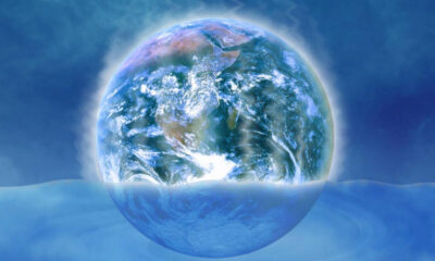 Earth depicted as a translucent bubble resting on a calm blue ocean.