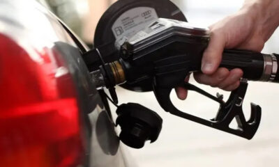 Close-up of a person pumping gas into a car at a fuel pump.