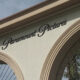 Paramount Pictures sign on a cream building with decorative arches and wrought-iron gates, palm trees nearby