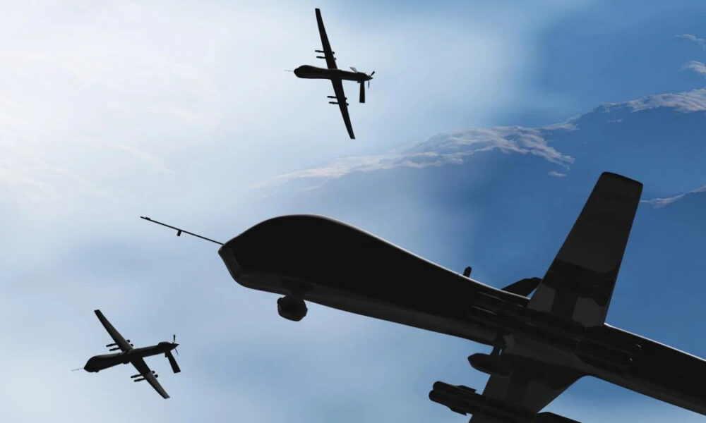 Three dark aircraft silhouettes fly in formation against a bright blue sky, viewed from below.