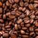 Close-up of shiny roasted coffee beans filling the frame.