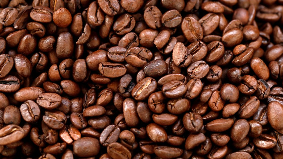 Close-up of shiny roasted coffee beans filling the frame.