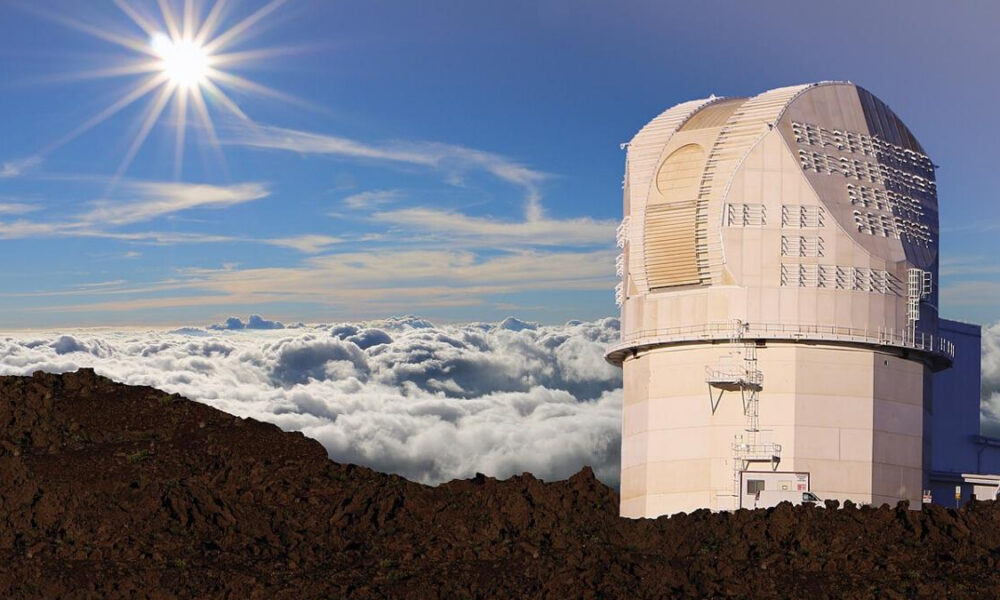 Observatory dome on a rocky mountaintop above the clouds with a bright sun in a clear blue sky.