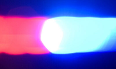 Red and blue emergency lights flashing, suggesting a police or emergency vehicle at night.