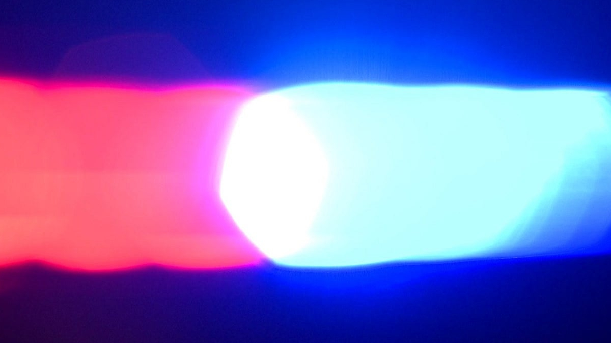 Red and blue emergency lights flashing, suggesting a police or emergency vehicle at night.