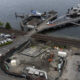 Aerial view of a waterfront dock with ferries, a pier, and a nearby construction site along the waterway