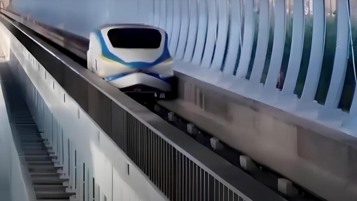 High-speed train gliding along an elevated curved track beside a glass-walled tunnel.