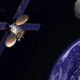 Satellite with blue solar panels orbiting Earth, Moon visible in the distance in space setting.