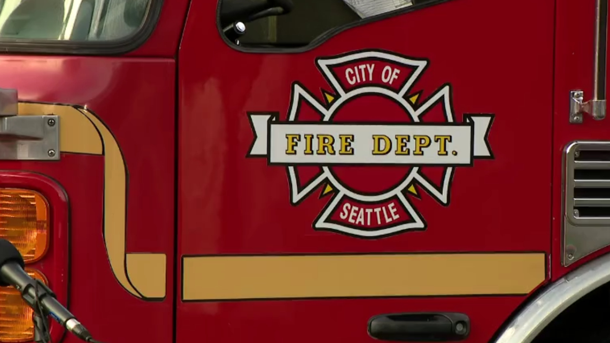 Red fire department vehicle with Seattle City of Fire Dept emblem on the door panel.
