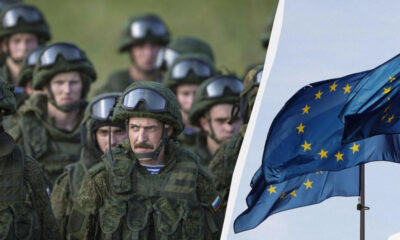 Group of armed soldiers in camouflage on the left, with a waving European Union flag on the right.