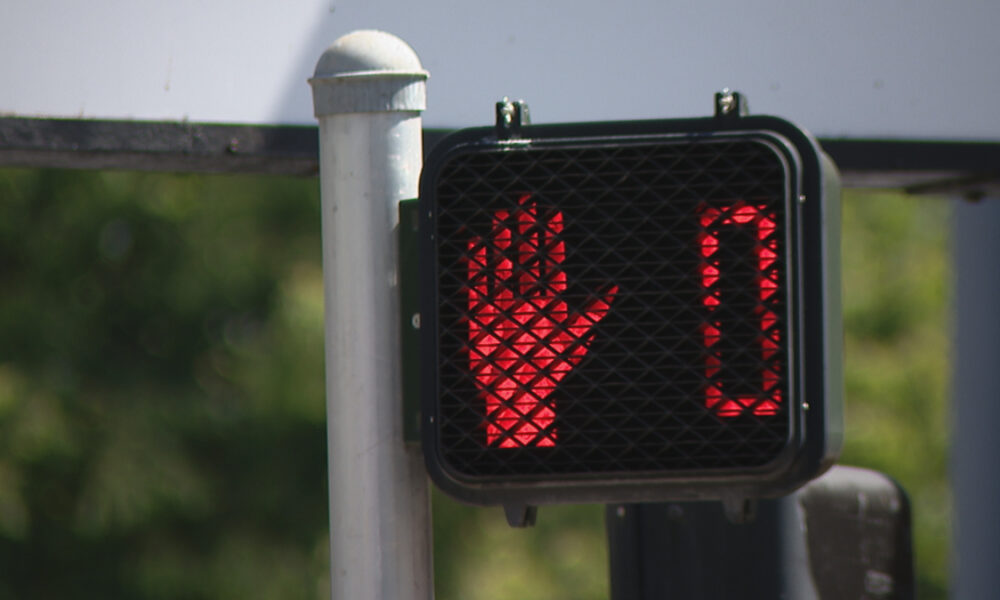 Pedestrian crossing signal showing a red 'don't walk' hand and a 0 timer.