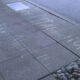 Sidewalk chalk messages in white and purple along a curb, with a parked car wheel visible.