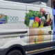 Food distribution van with 'Food Connection' branding and groceries graphic on the side, part of a community food program.