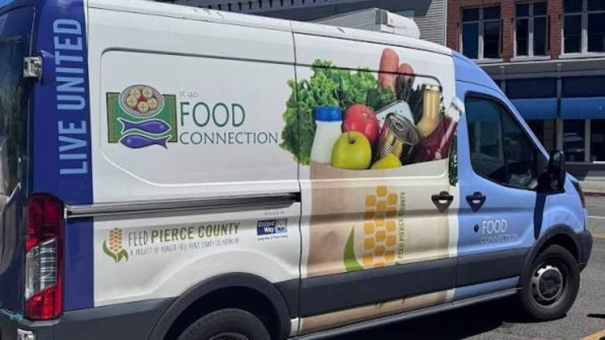 Food distribution van with 'Food Connection' branding and groceries graphic on the side, part of a community food program.