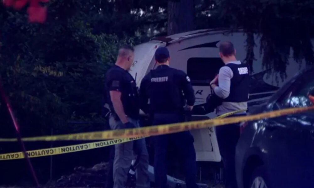 Three sheriffs in vests inspect a white van behind yellow crime-scene tape in a dim, outdoor area.