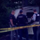 Three sheriffs in vests inspect a white van behind yellow crime-scene tape in a dim, outdoor area.