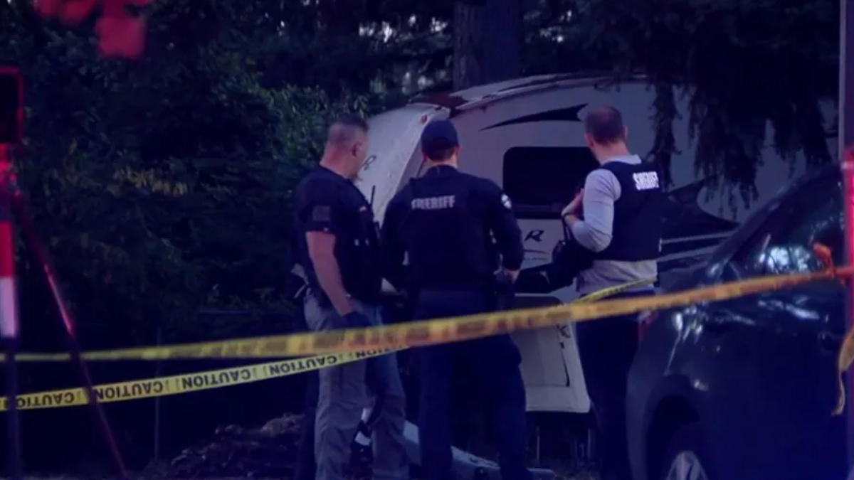 Three sheriffs in vests inspect a white van behind yellow crime-scene tape in a dim, outdoor area.