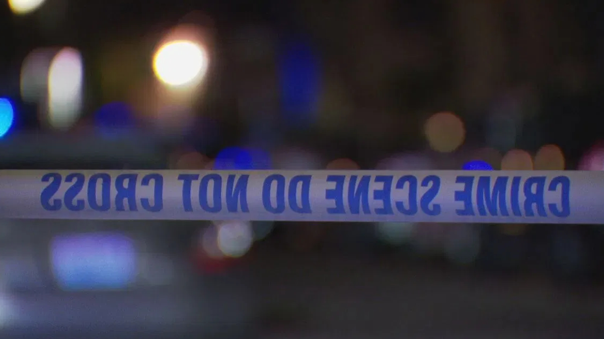 Police tape reading 'CRIME SCENE DO NOT CROSS' across a dimly lit street with blurred city lights in the background.