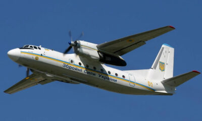 White Ukrainian military aircraft in flight with 'Збройні Сили України' along the fuselage and Ukrainian insignia on the tail.