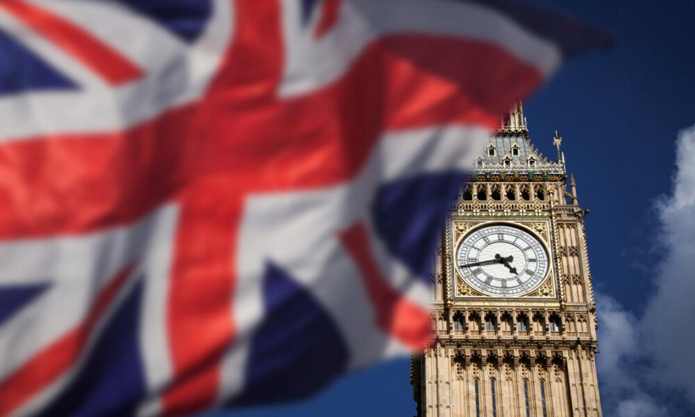 Big Ben clock tower in London with a blurred Union Jack flag in the foreground